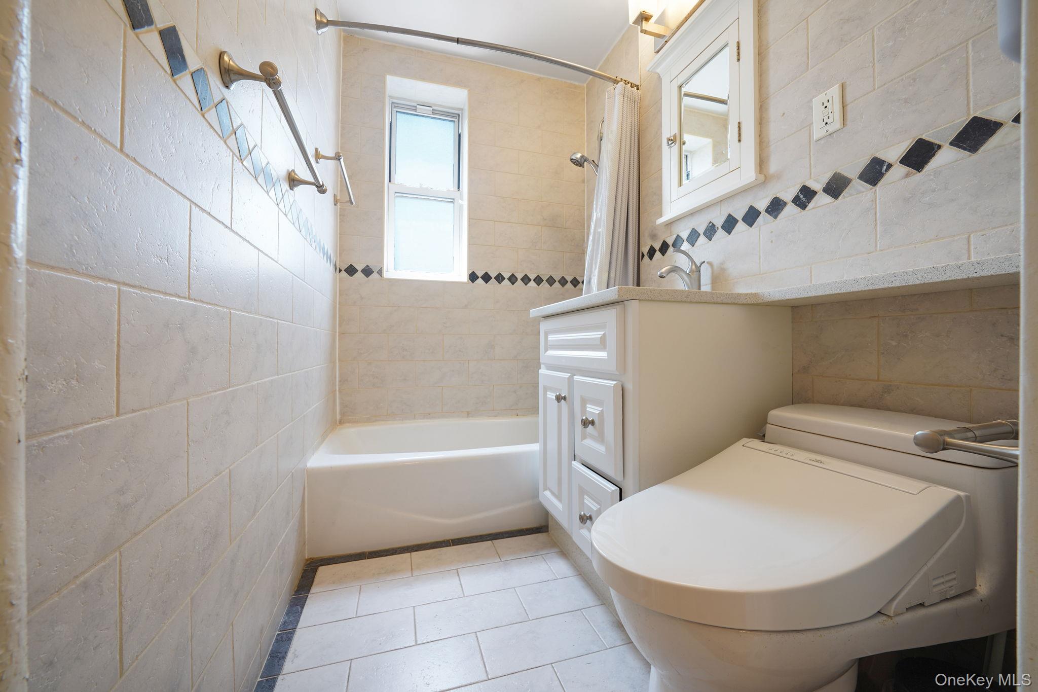 103-26 68th Avenue, Unit 2E Queens, NY 11375 - Photo 19 of 22 Full bath featuring tile walls, tile patterned floors, shower / tub combo with curtain, vanity, and toilet