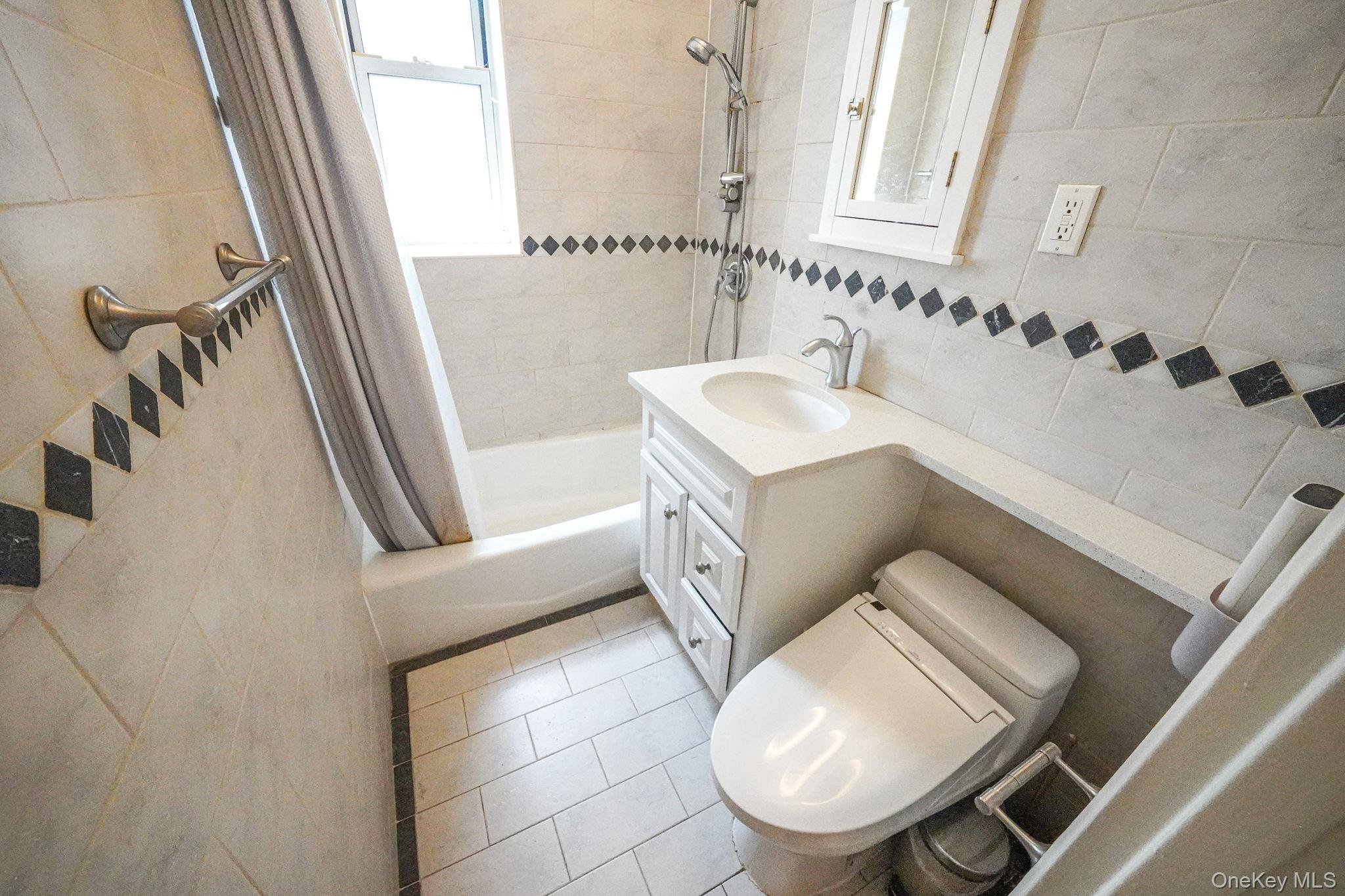 103-26 68th Avenue, Unit 2E Queens, NY 11375 - Photo 20 of 22 Bathroom featuring tile walls, shower / tub combo, toilet, tile patterned flooring, and vanity