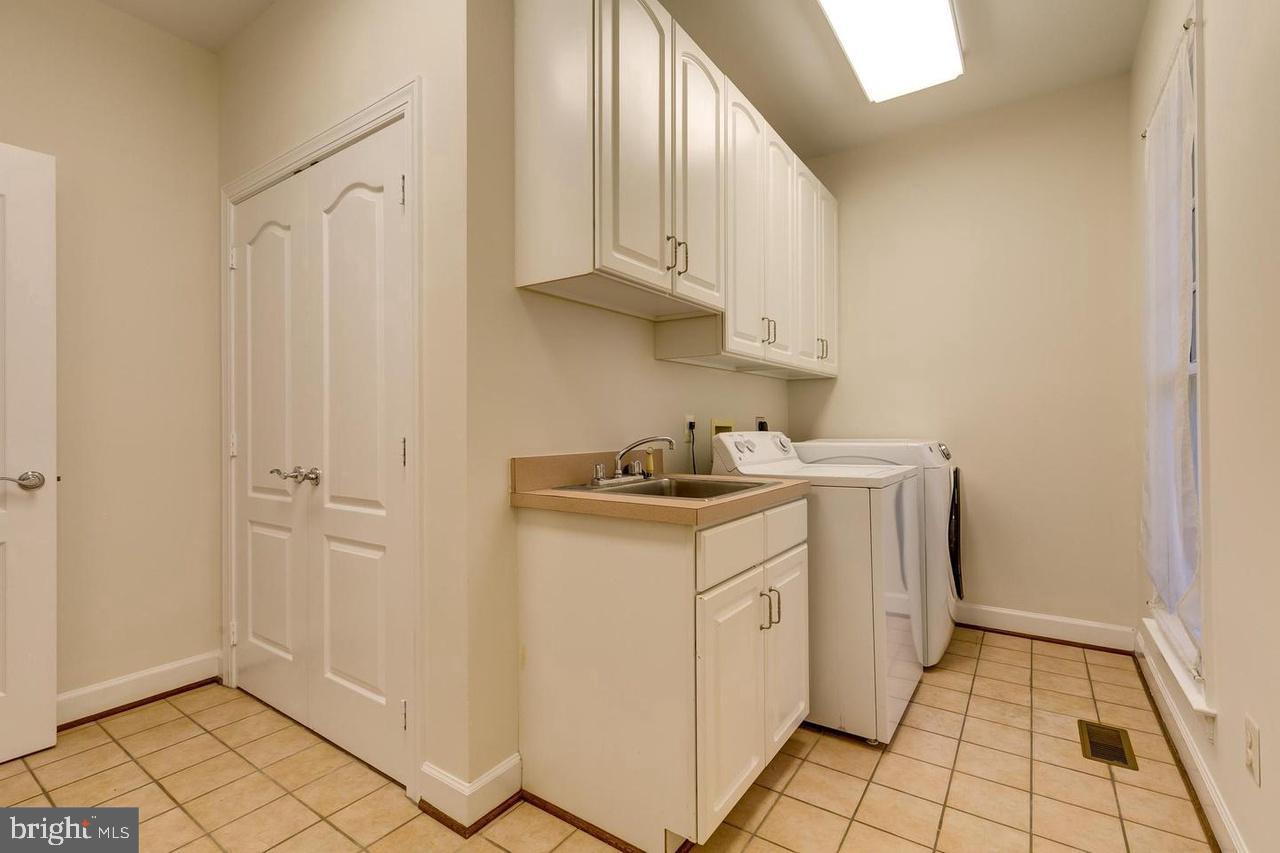 1489 Broadstone Place Vienna, VA 22182 - Photo 17 of 20 a utility room with cabinets washer and dryer