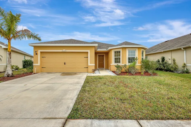 a front view of a house with a yard and garage