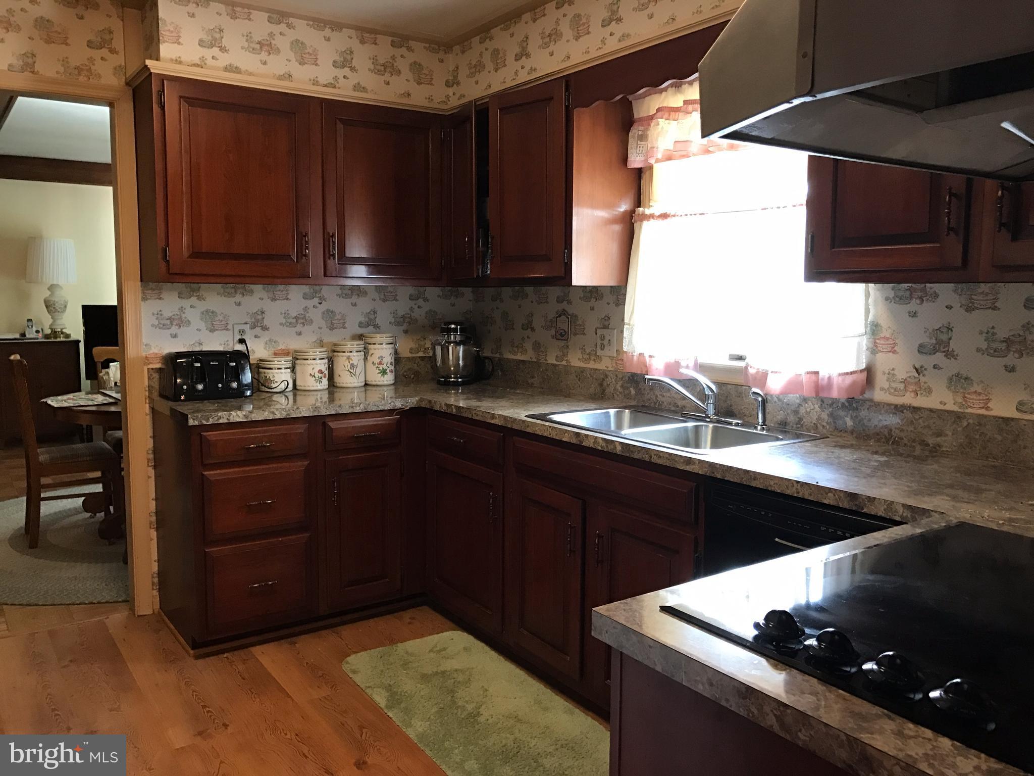 3121 Carroll Road Huntingtown, MD 20639 - Photo 16 of 26 a kitchen with a sink a stove and wooden cabinets
