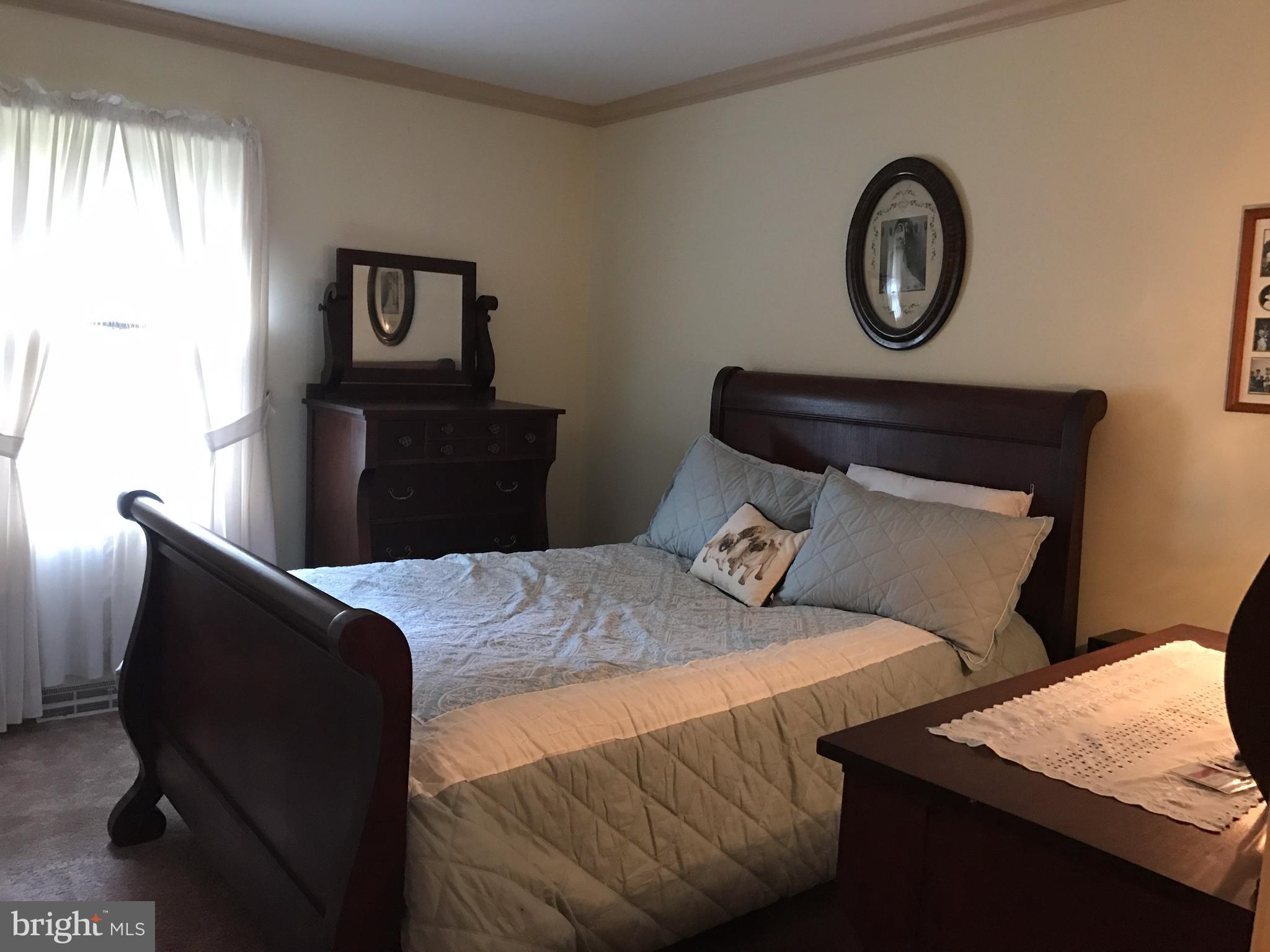 3121 Carroll Road Huntingtown, MD 20639 - Photo 3 of 26 a bedroom with a bed and a chair
