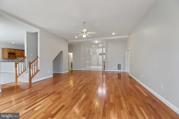 a view of a hallway with wooden floor and staircase