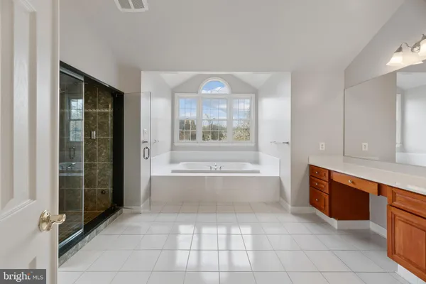 a view of an empty room with wooden floor and windows