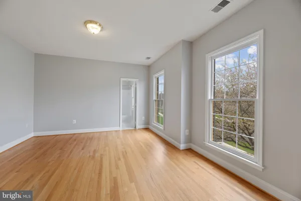 a view of an empty room with wooden floor