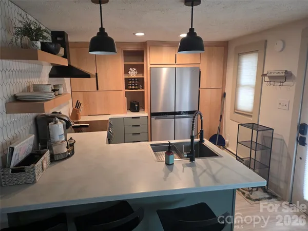 a kitchen with stainless steel appliances granite countertop a sink refrigerator and microwave