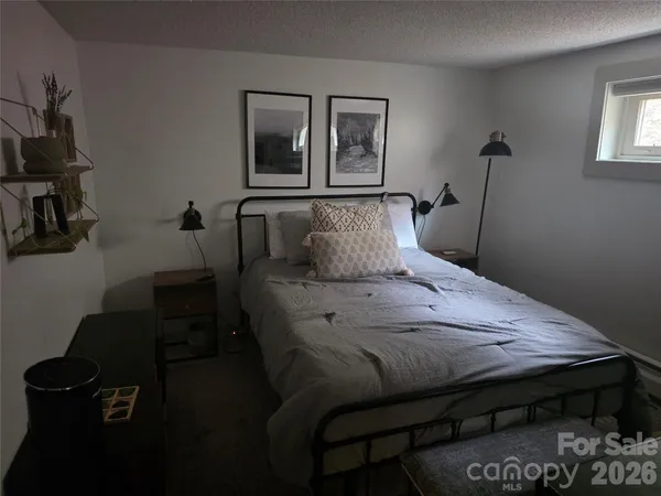 a bedroom with a bed wooden floor and window