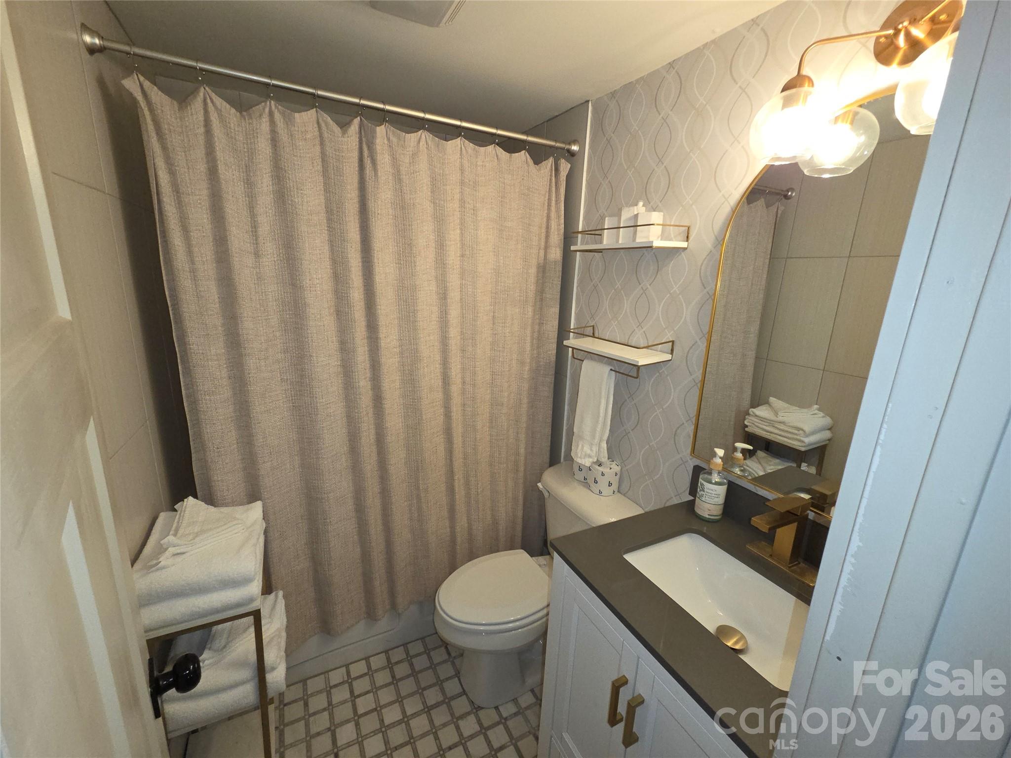 108 Northridge Road, Unit 1B Banner Elk, NC 28604 - Photo 19 of 34 a bathroom with a sink a toilet and shower curtain