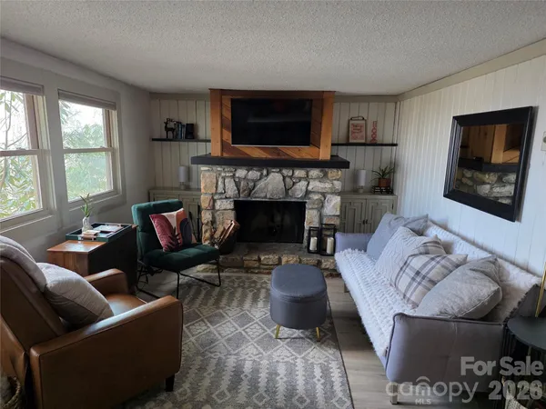 a living room with furniture a flat screen tv and a fireplace