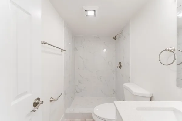 a white toilet sitting next to a bath tub