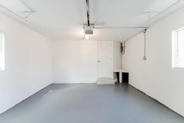 an empty room with wooden floor ceiling fan and windows