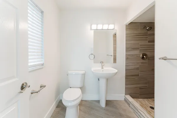 a bathroom with a sink a toilet and shower