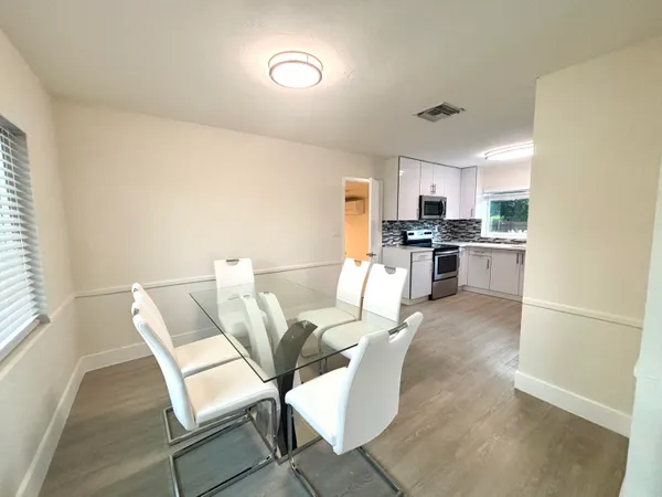 a living room with stainless steel appliances furniture a rug and a kitchen island