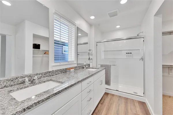 a bathroom with a granite countertop sink mirror and a shower