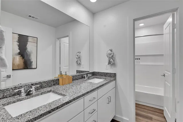 a bathroom with a granite countertop sink and a mirror