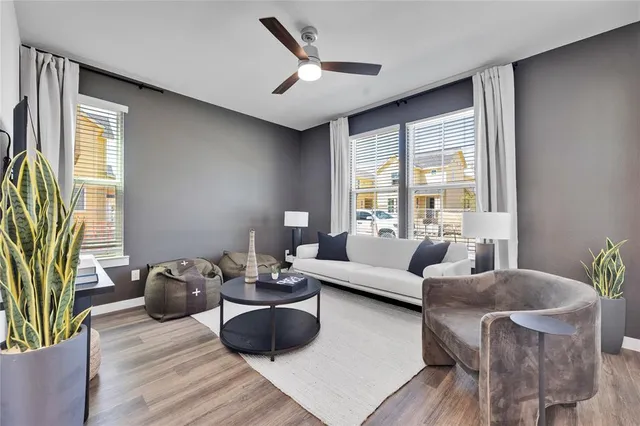 a living room with furniture potted plant and a large window