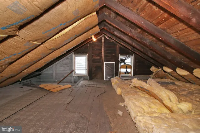 a bed sitting in a bedroom next to a window and a mirror