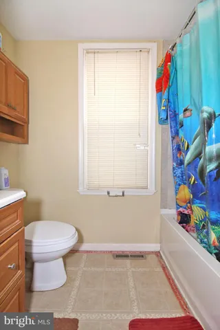 a bathroom with a toilet and a shower curtain