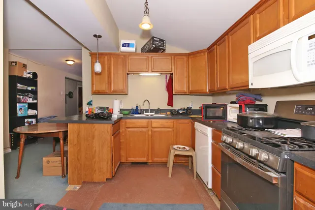 a kitchen with stainless steel appliances granite countertop a stove top oven a sink dishwasher and cabinets with wooden floor