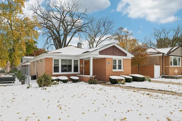 a front view of a house with yard covered in snow
