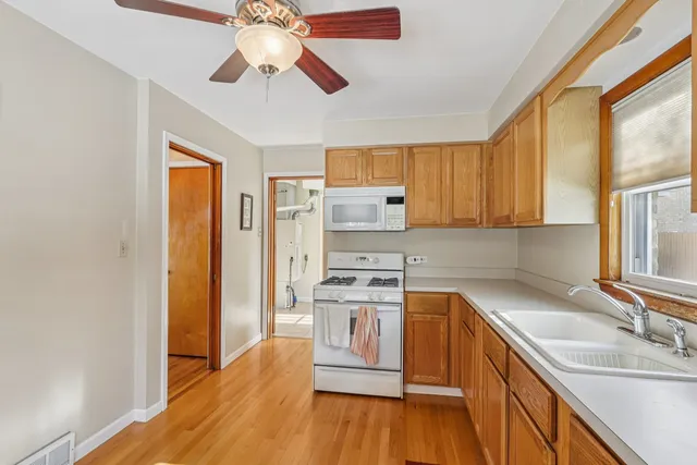a kitchen with stainless steel appliances granite countertop a sink cabinets and wooden floor