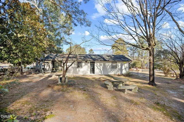 a view of a house with a yard and tree