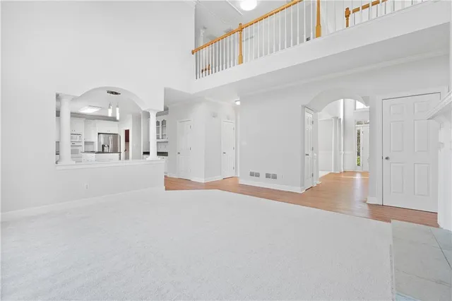 a kitchen with stainless steel appliances granite countertop a sink dishwasher stove and white cabinets with wooden floor