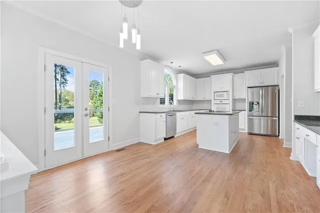 a kitchen with granite countertop white cabinets and white appliances