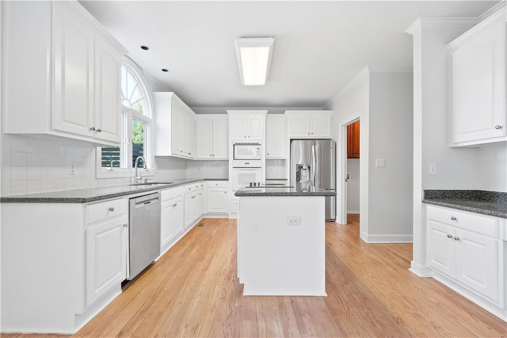 1810 Sunset Harbour Pointe Lawrenceville, GA 30043 - Photo 17 of 56 a kitchen with granite countertop white cabinets and white appliances