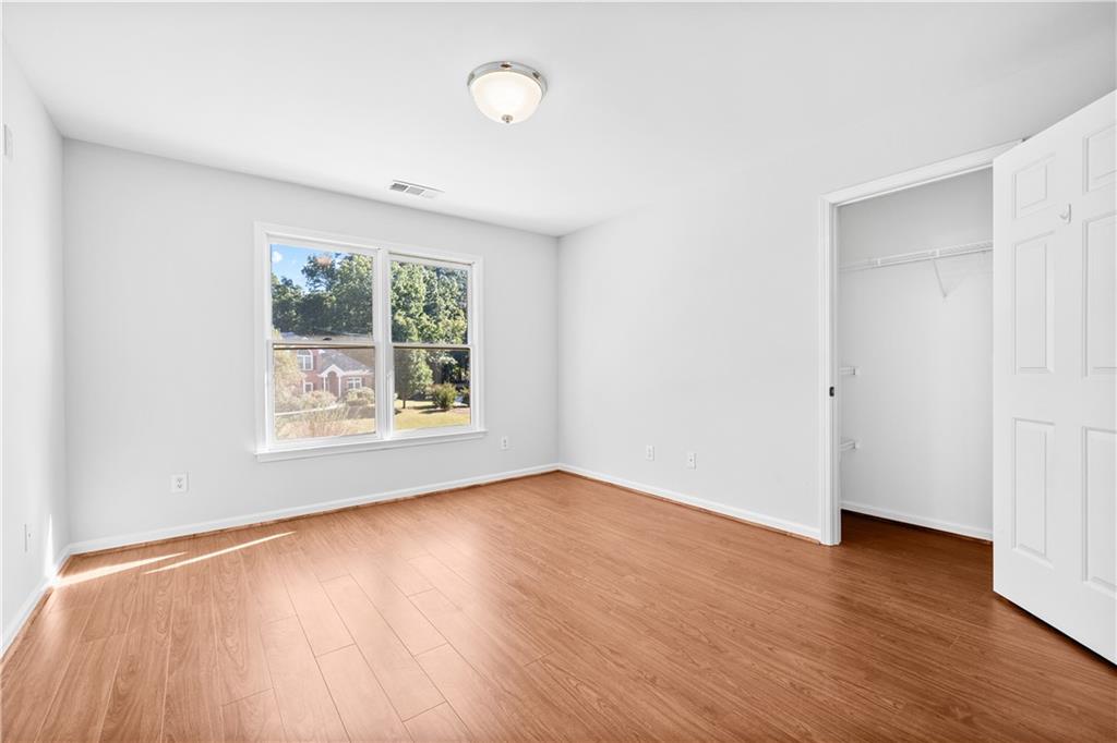 1810 Sunset Harbour Pointe Lawrenceville, GA 30043 - Photo 32 of 56 an empty room with wooden floor and windows