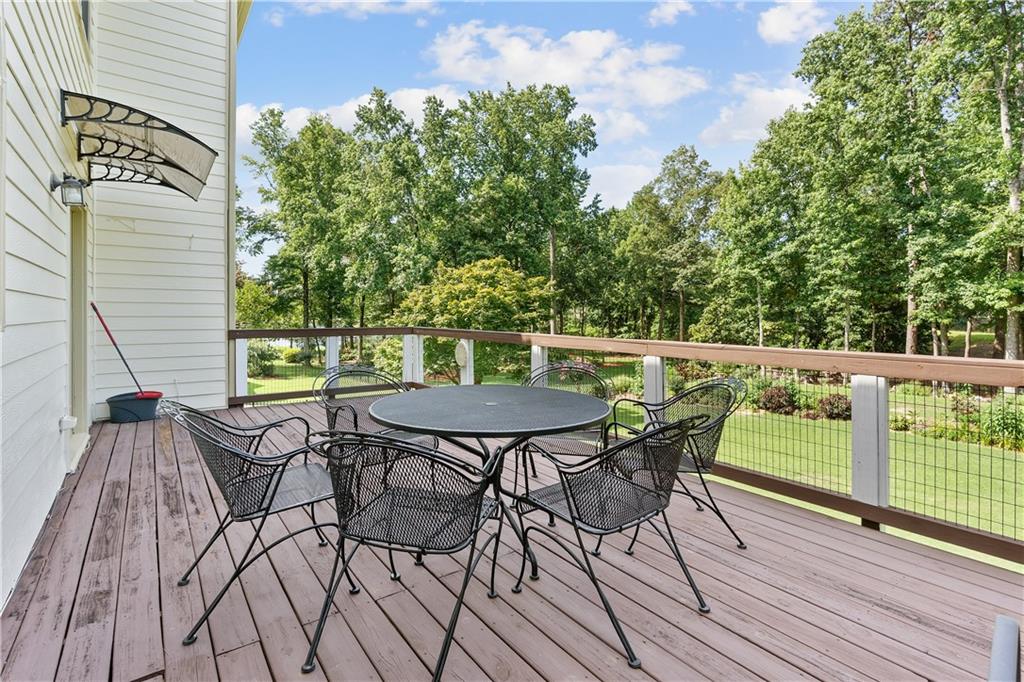 1810 Sunset Harbour Pointe Lawrenceville, GA 30043 - Photo 44 of 56 a view of a roof deck with table and chairs and wooden floor