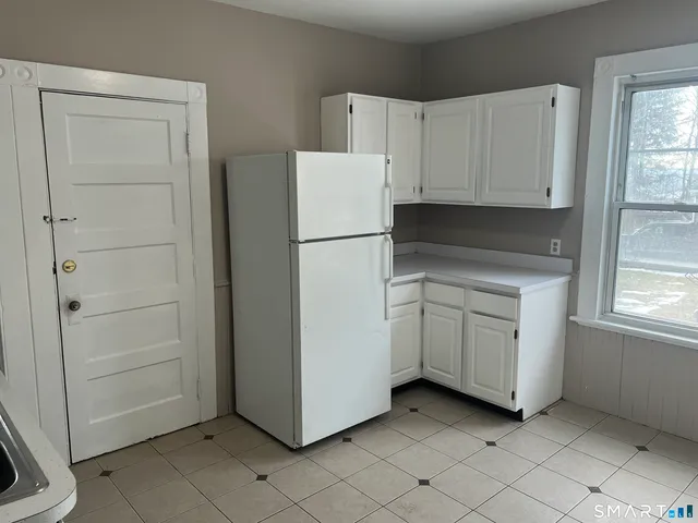 a view of a kitchen with white cabinets