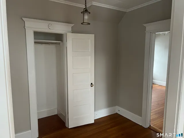 a view of an empty room with wooden floor