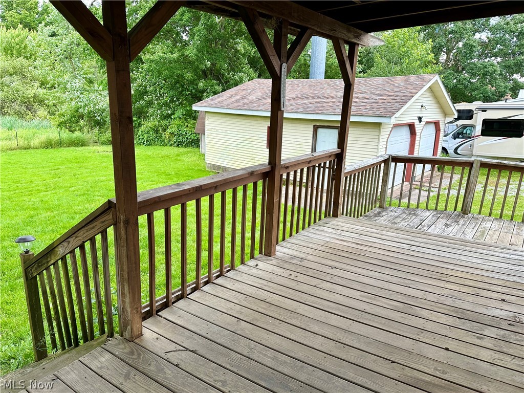 6841 Warren - Sharon Road Brookfield, OH 44403 - Photo 24 of 32 Wooden terrace featuring a garage and a lawn