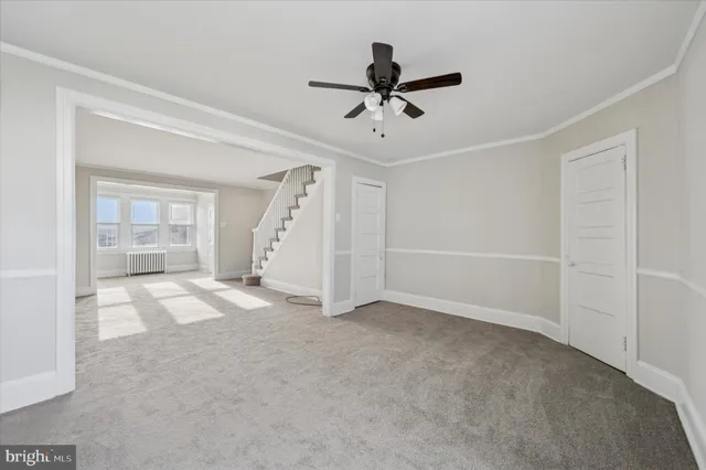 a view of empty room with wooden floor and ceiling fan