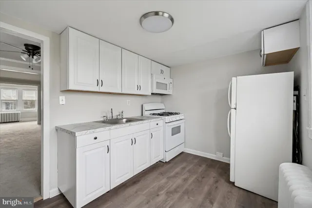 a kitchen with cabinets appliances and a wooden floor