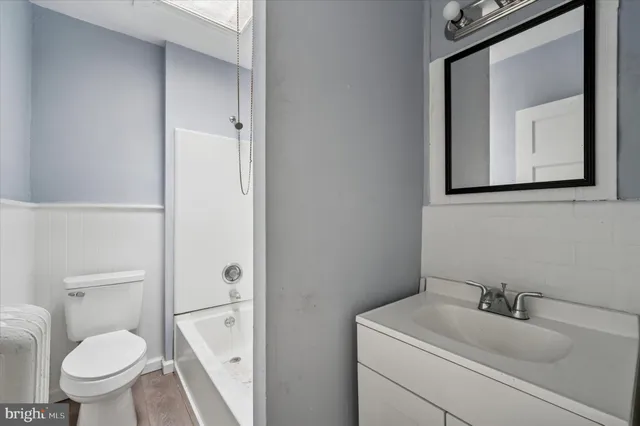 a bathroom with a toilet sink vanity and mirror