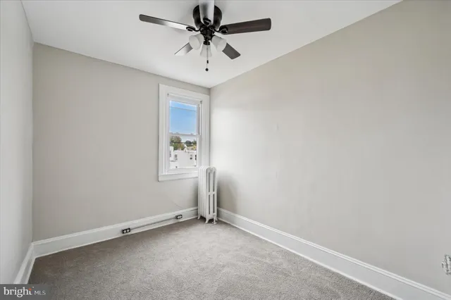 an empty room with a fan & a ceiling fan