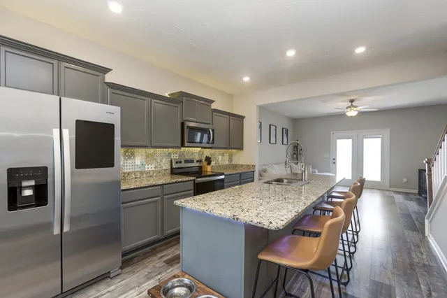 a kitchen with a table chairs refrigerator and microwave