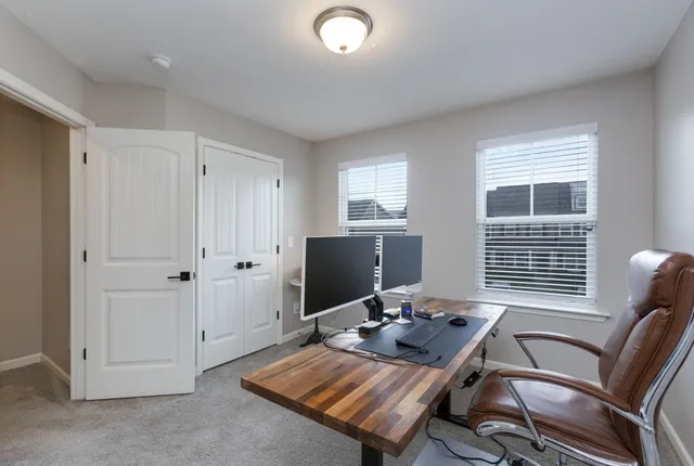 a view of a workspace with furniture and a window
