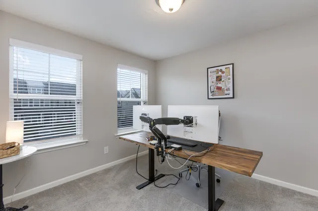 a view of a workspace with furniture and a window