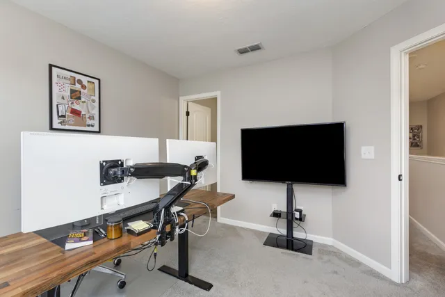 a view of a livingroom with workspace and a window