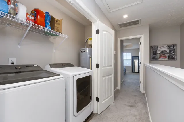 a view of washer and dryer with kitchen in the background
