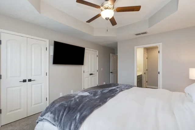 a bedroom with a large bed and a flat tv screen