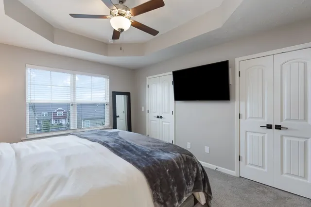 a bedroom with a bed tv and a window