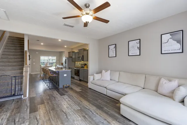 a living room with furniture kitchen view and a chandelier