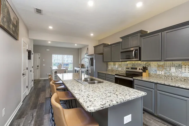 a kitchen with kitchen island granite countertop a sink and microwave