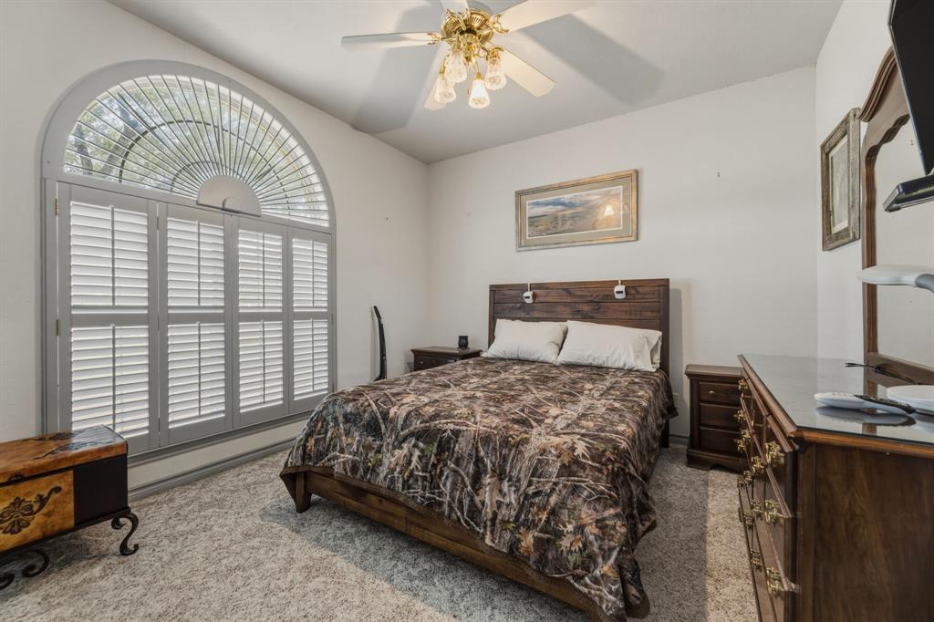 130 Blazek Road Alma, TX 75119 - Photo 27 of 34 a bedroom with a bed and a chandelier