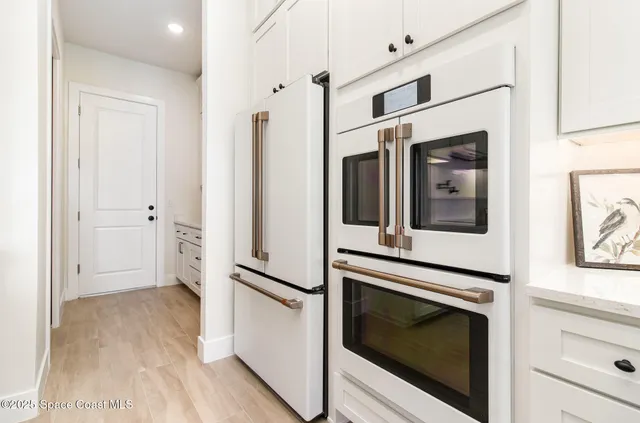 a kitchen with white cabinets and sink