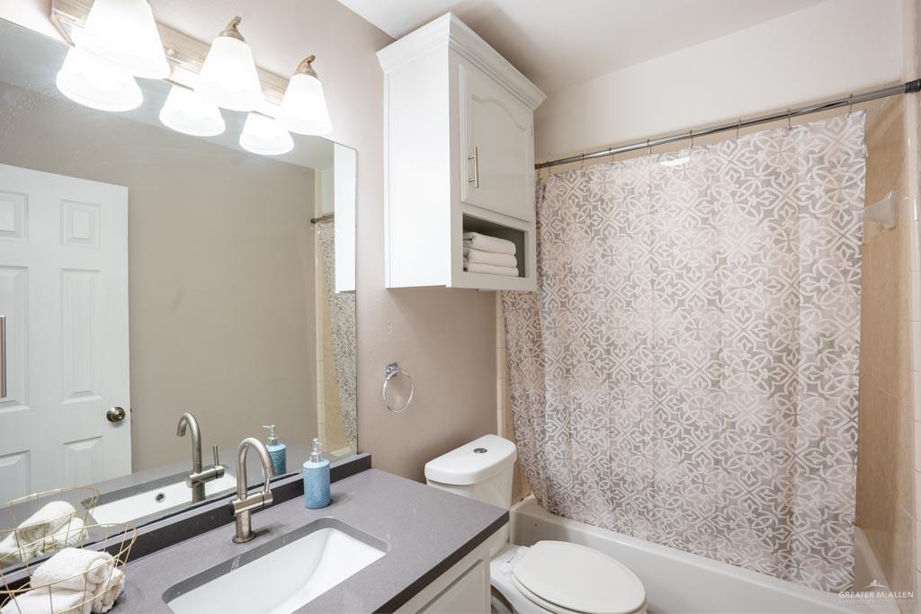 5108 South 33rd Street McAllen, TX 78503 - Photo 6 of 17 a bathroom with a toilet a sink and a mirror